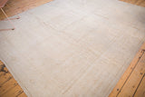 Distressed vintage Oushak rug with low pile, subtle tone-on-tone pattern in ivory and beige.