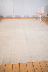 Subtle tone-on-tone texture of the distressed low pile vintage Oushak rug's secured end.