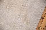Textural low pile of the distressed Oushak carpet, revealing soft ivory, beige, and sand hues.