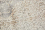 Distressed vintage Sparta carpet detail shows even wear, faded ivory, grey, beige motifs.
