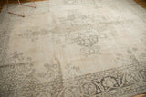 Distressed vintage Sivas carpet border with faded charcoal floral motifs on an ivory-beige field.