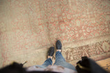 Distressed vintage Anatolian carpet section with faded raspberry Herati motifs and worn, low pile.