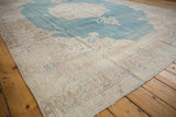 Wide ivory border and scrolling corner spandrel of a distressed vintage Sivas rug.
