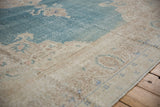 Evenly worn texture of a distressed vintage carpet, showing the ivory border and sky blue field.