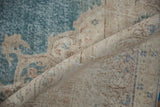 Folded corner of a distressed Sivas rug showing the even wear and hand-knotted foundation.