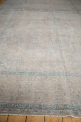 Light foundation showing through distressed pale blue and apricot floral patterns on vintage Kashan.