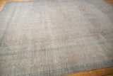 Vintage distressed Kashan carpet shows even wear, subtle scrolling vinery, and pale blue details.