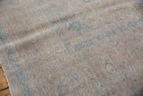 Distressed texture and faded pale dusty powder blue patterns on a vintage Kashan carpet.