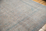 Distressed texture of the vintage Kashan carpet, with muted apricot and pale blue floral patterns.