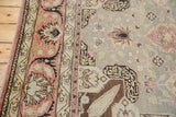 Ornate corner motif in dusty blue, terracotta, and ivory on a distressed vintage Kaisary rug.