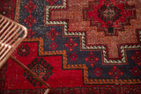 Vintage Belouch rug, showing geometric stepped motifs with cherry red, navy, and dusty raspberry.