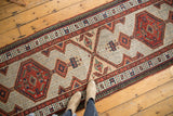 Geometric medallion and vinery design on a vintage Serab rug runner in sand, tomato red, and sky blue.