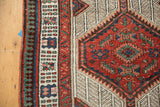 Close-up of Vintage Serab runner with highly ornamented geometric motifs in red, blue, and sand.