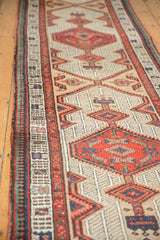 Vintage Serab runner showing geometric patterns, red diamond motifs, and patterned side border.