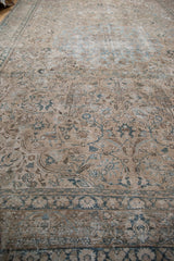 Distressed vintage Tabriz carpet with faded antique ivory field, dusty teal motifs, even wear.