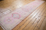 Distressed Oushak runner, low pile texture with pastel pink, blue, ivory geometric patterns.