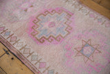 Distressed Oushak runner shows pink gul, rams horn motif, low pile, and visible knot heads.