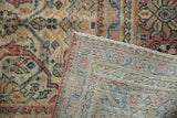 Distressed vintage Mahal carpet detail: worn pile with intricate arabesques and woven foundation.