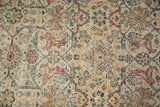 Distressed Mahal rug's intricate arabesque design in terra cotta, ivory, and blue with visible pile wear.