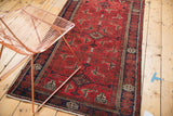 Geometric Herati-inspired motif across the vintage Belouch runner's brick red field.