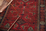 Low pile geometric Herati motif in brick red and navy on vintage Belouch runner.