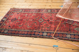 Dark navy and brick red geometric border of a vintage Belouch rug's secured end.
