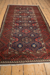 Repeating geometric floral field in navy, red, ivory with even wear on Belouch runner.