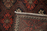 Vintage Belouch rug displaying ivory fringe, secured side, and geometric pattern on reverse.