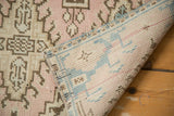 Distressed Oushak rug pile texture with blush and sand tones, revealing its hand-knotted back.