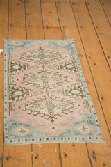 Bottom corner of the distressed Oushak rug, with secured side and ivory fringe.