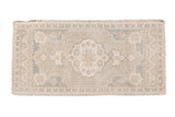 Distressed vintage Oushak rug, central scalloped medallion, silver, ivory, and pale slate blue tones.