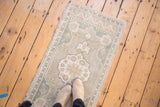 Distressed vintage Oushak rug with pale blue, ivory border and intact side selvage.