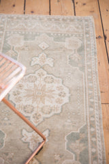 Even wear on scalloped medallion of vintage distressed Oushak rug, pale blue and ivory.