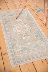 Worn ivory and pale slate blue border pattern on a Vintage Distressed Oushak rug corner.