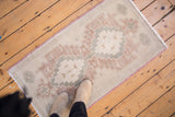 Distressed Oushak rug, softened pile with ivory, faded burgundy, and muted silver pattern.