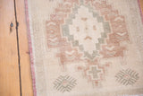 Distressed vintage Oushak rug detail: faded burgundy, silver geometric motifs, and even wear.