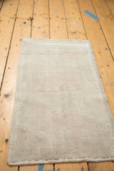 Partial view of the vintage distressed Oushak rug, showing soft low pile and subtle abrashes in beige and sand tones.