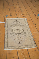 Distressed Oushak rug lower border, ivory fringe, charcoal vine, and even wear.