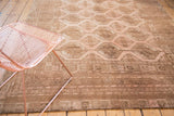 Distressed blush and coffee brown gul motifs with detailed border on the vintage Afghan carpet.