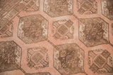Repeating peach and brown gul motifs with diminutive inner guls on distressed vintage Afghan rug.
