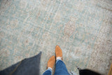 Pale ocean green distressed Sivas carpet, with aged vase motif and feet.
