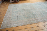 Faded pale ocean green and antique ivory hues on the textured pile of a distressed Sivas carpet.