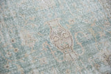 Distressed texture and vase motif on a pale ocean green and ivory vintage Sivas carpet.
