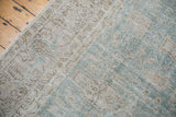 Distressed pile of the Sivas carpet showcasing somewhat even wear in muted green and ivory.