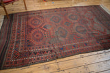 Antique Belouch carpet, geometric gul patterns in cherry red, navy, and kilim ends.