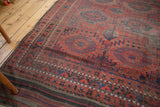 Geometric border of an antique Belouch rug with cherry red tones and original plainwoven kilim end.