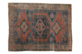Distressed vintage Persian Veece rug with dusty teal and burnt orange geometric medallion.