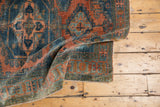 Distressed low pile texture of the vintage Veece rug, with dusty teal and burnt orange.
