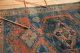 Distressed Veece rug with low pile, exposed knot heads, geometric dusty teal and burnt orange.