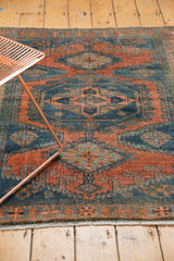 Distressed vintage Veece rug corner, showing low pile, knot heads, dusty teal, and burnt orange.